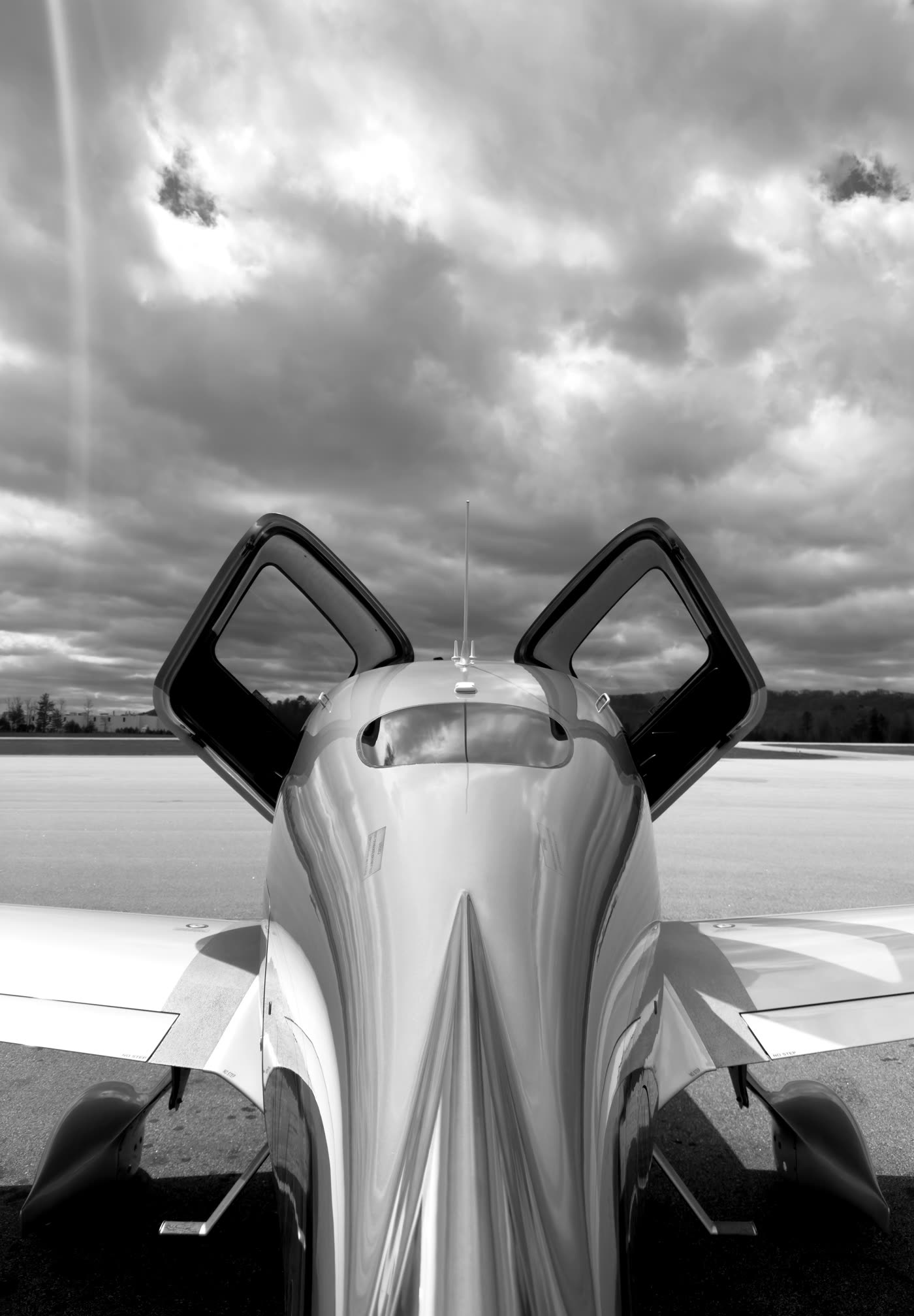 Cirrus SR with both doors open on the ramp beneath a dramatic sky