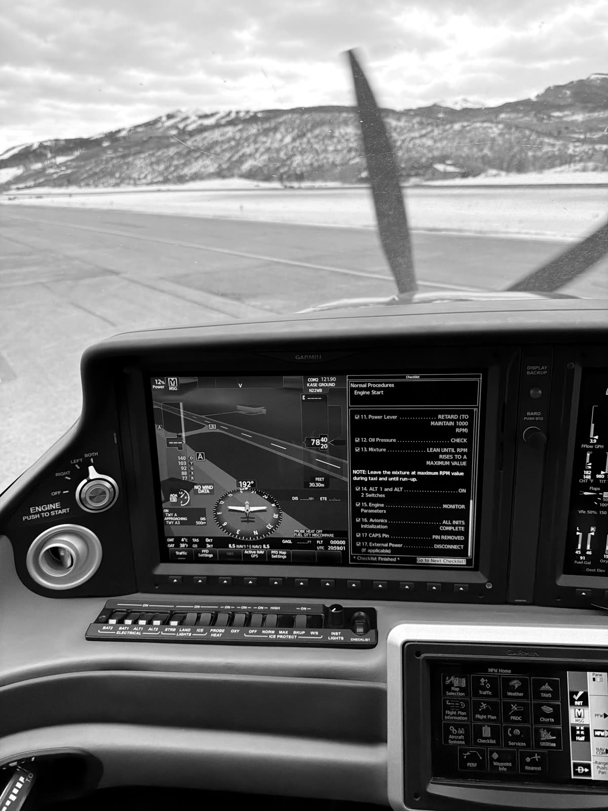 Snow-covered mountains behind the propeller during engine start at Aspen